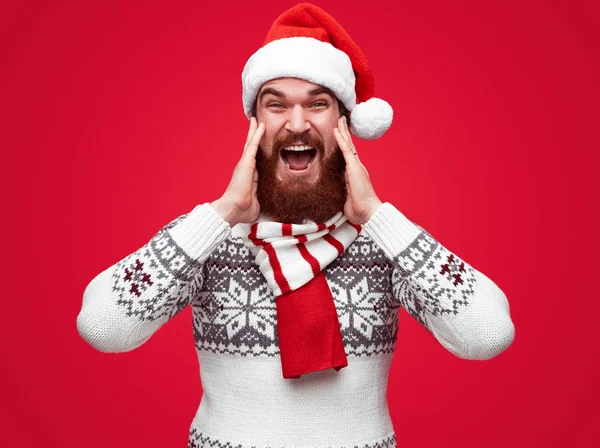 Счастливый человек в зимнем пуловере и шляпе санта кричит от счастья — стоковое фото