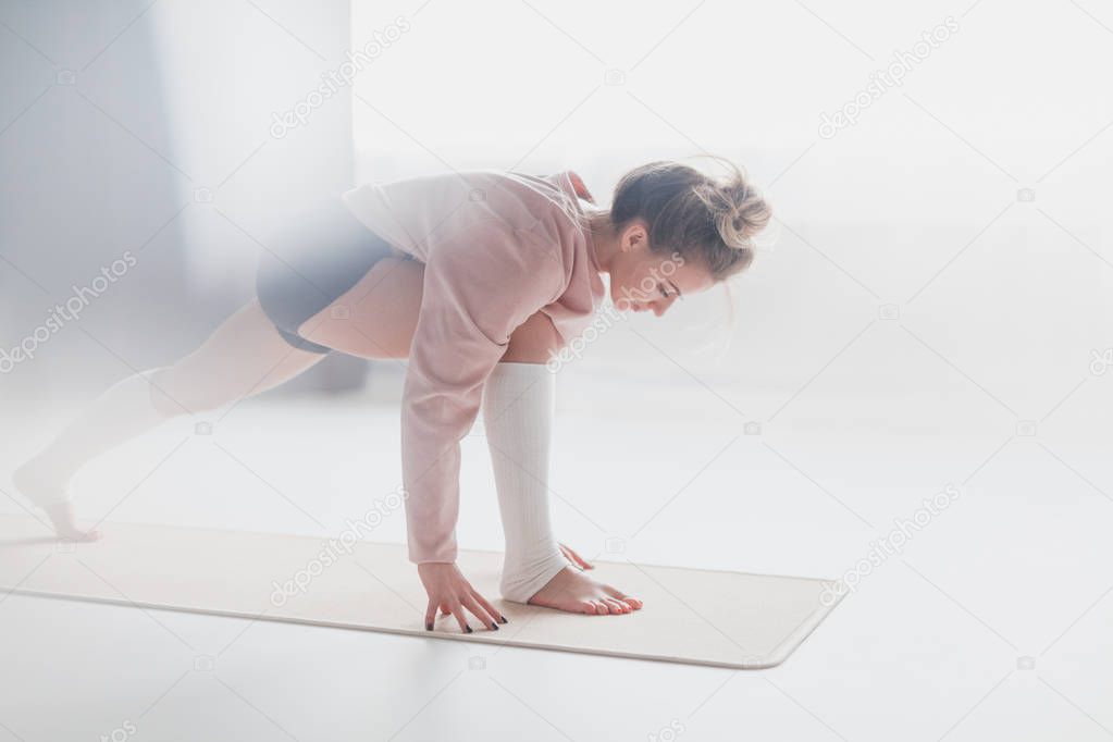 Young woman training on yoga mat