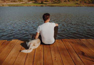 Adam ile köpek uzak ahşap iskele üzerinde