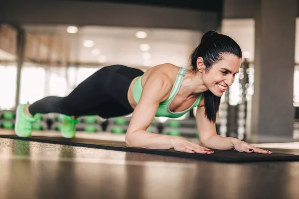 Smiling lady doing plank in gym — Stock Photo, Image