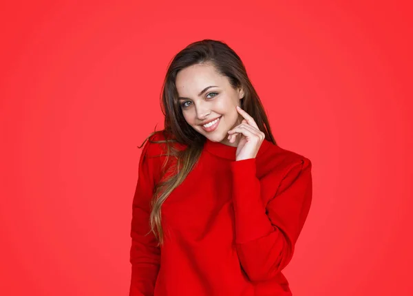 Beautiful smiling brunette on red background — Stock Photo, Image