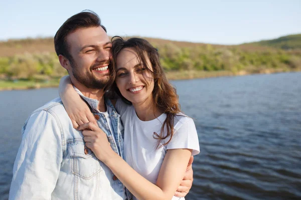 Iloinen pari halailemassa lähellä järveä — kuvapankkivalokuva