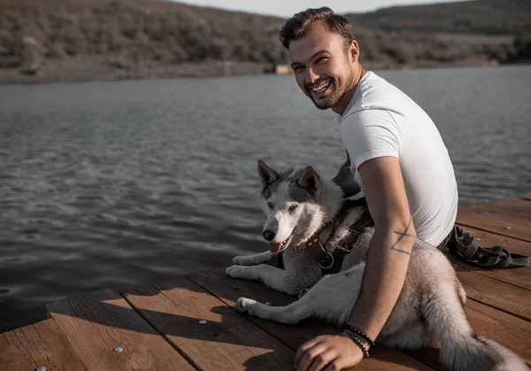 Hombre feliz con perro en el muelle — Foto de Stock