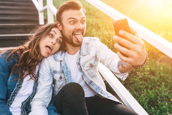 Coppia smorfie e prendere selfie — Foto Stock