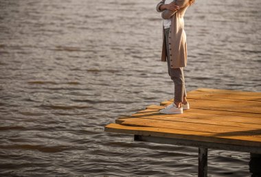 Suya yakın iskelede duran kırpma kadın