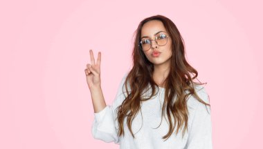 Dudaklar somurtarak ve v-sign gösterilen güzel kız