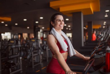 Gülümseyen kadın koşu bandında yürüyüş