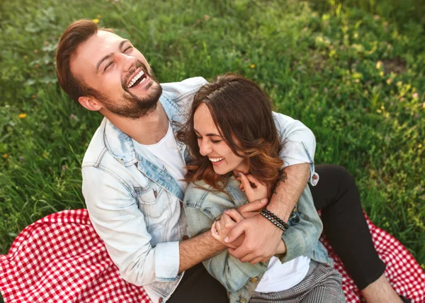 Jovem abraçando namorada e rindo no campo — Fotografia de Stock