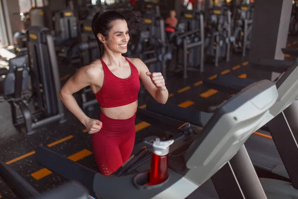 Cheerful woman running on treadmill — Stock Photo, Image
