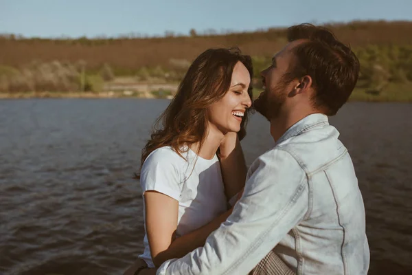 Lachendes junges Paar am See lizenzfreie Stockfotos