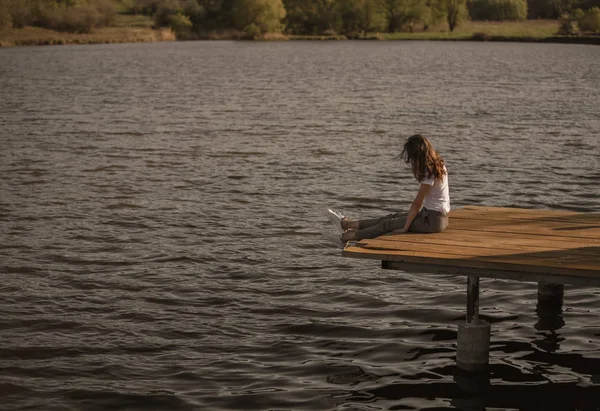 Donna casuale sul molo sopra l'acqua del lago — Foto Stock