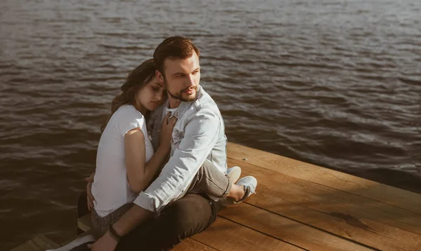 Man embracing sleeping woman on pier — Stock Photo, Image