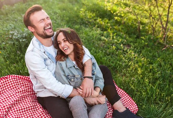 Laughing couple sitting on green grass — 图库照片