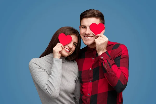 Pareja sonriente con corazones cerca de los ojos — Foto de Stock