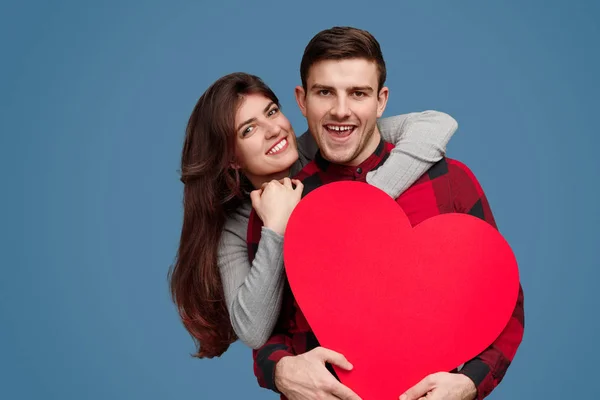 Vrolijke vrouw knuffelen man met een groot hart — Stockfoto