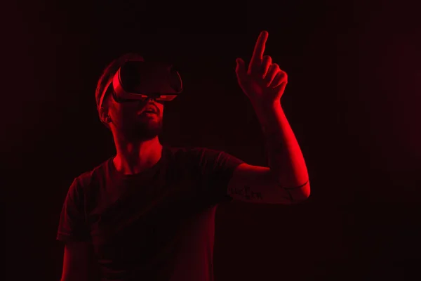 Случайный человек в темноте с помощью VR гарнитуры — стоковое фото