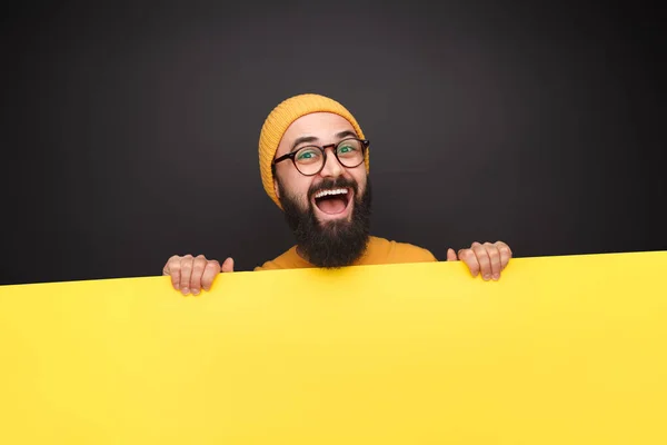 Bright guy with blank yellow poster — Stock Photo, Image