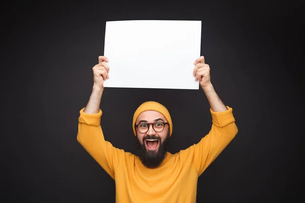 Podekscytowany mężczyzna pokazuje pusty papier — Zdjęcie stockowe