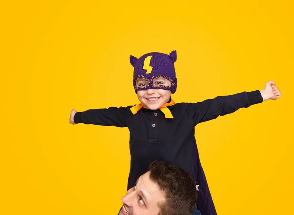 Мальчик в маске супергероя сидит на шее отца — стоковое фото