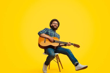 Trendy hipster gitar çalıyor ve şarkı