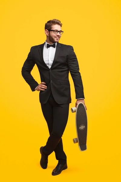 Homme musclé à la mode en costume avec skateboard — Photo