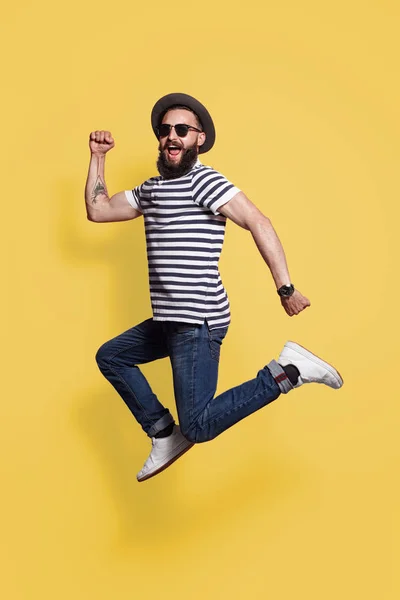 Hipster man in hat and sunglasses jumping — Stock Photo, Image