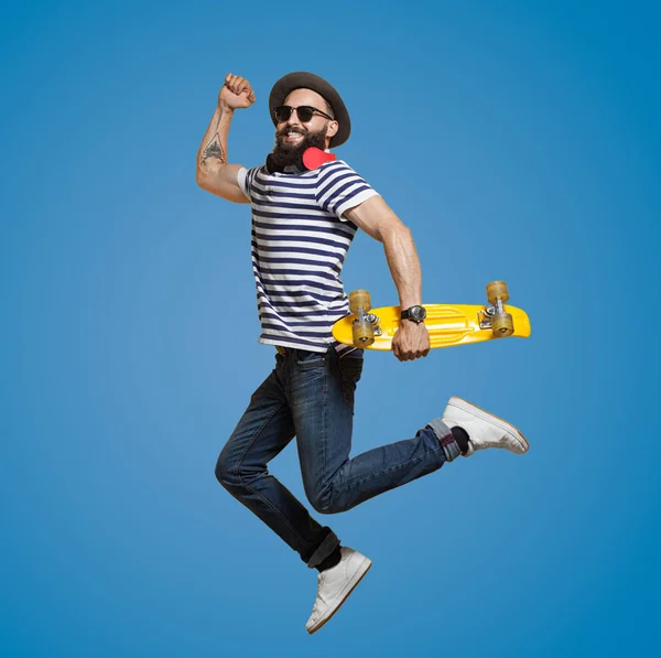 Modern Hipster jumoing on blue background — Stock Photo, Image