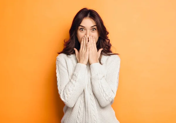 Mujer joven asombrada sobre fondo naranja — Foto de Stock