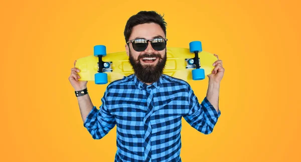 Hipster barbudo homem com um skate amarelo — Fotografia de Stock