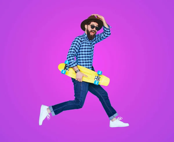 Hipster com barba em movimento sobre fundo roxo — Fotografia de Stock