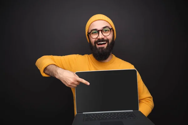 Smiling guy pointing at laptop — Stock Photo, Image