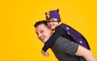 Neşeli çocuk kahraman örme maskesinde adamla