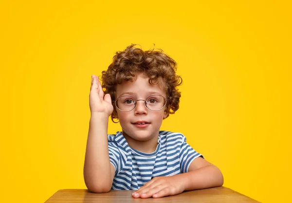 Adorable smart boy holding hand to give answer — Stock Photo, Image