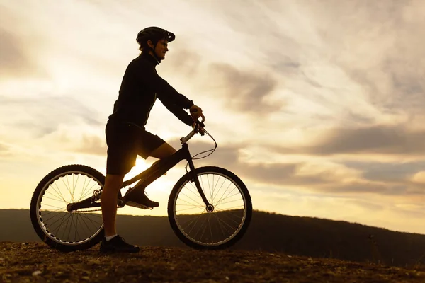 Człowiek na rowerze przed zachmurzonym niebie — Zdjęcie stockowe