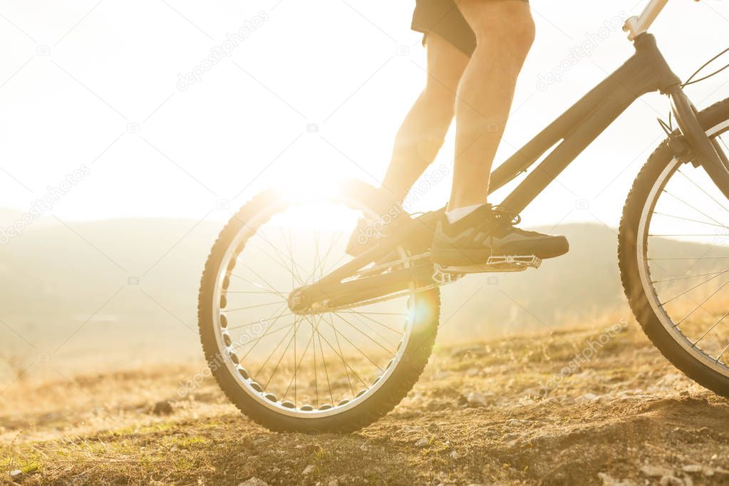 Crop legs on bike in nature
