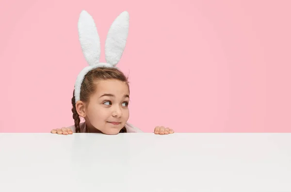 Niña juguetona en orejas de conejo blanco — Foto de Stock