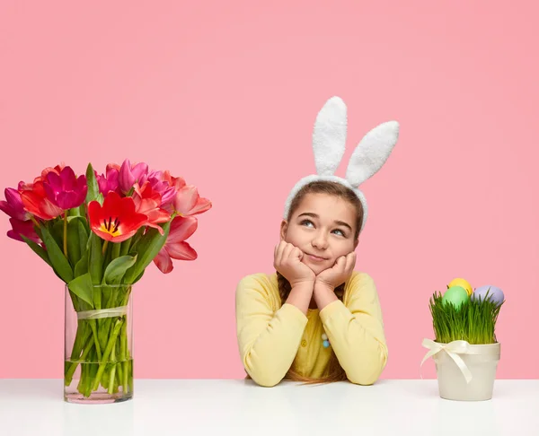 Chica de ensueño cerca de huevos de Pascua y flores — Foto de Stock