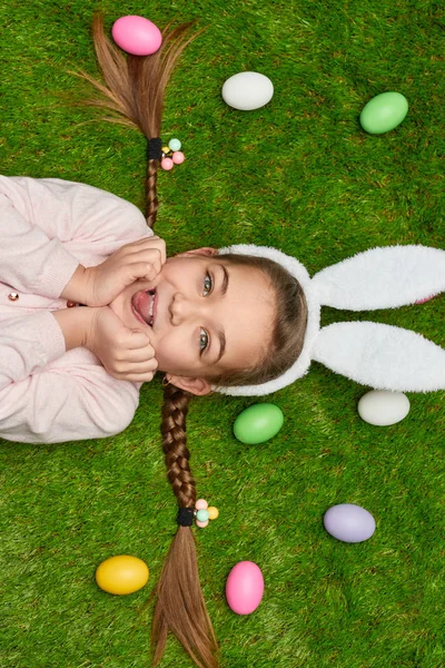 Gadis manis berbaring di rumput dengan telur Paskah — Stok Foto