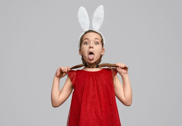 Chica divertida en orejas de conejo asfixia con trenzas — Foto de Stock
