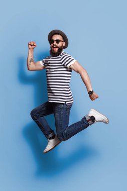 Trendy hipster mavi zemin üzerinde atlama 