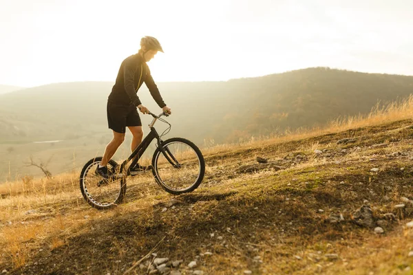 Stojąc na rowerze na wzgórzu sportowca — Zdjęcie stockowe