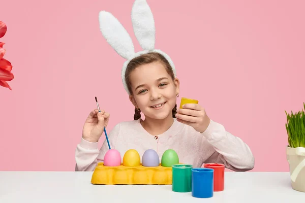 Chica sonriente pintando huevos de Pascua — Foto de Stock