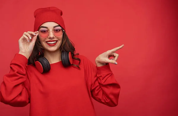 Menina elegante em roupa vermelha apontando para longe — Fotografia de Stock