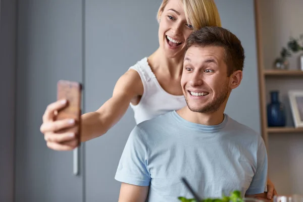 Uśmiechający się para biorąc selfie w domu — Zdjęcie stockowe