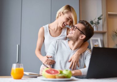 Kadın adam masada dizüstü ve Not Defteri ile kucaklayan 