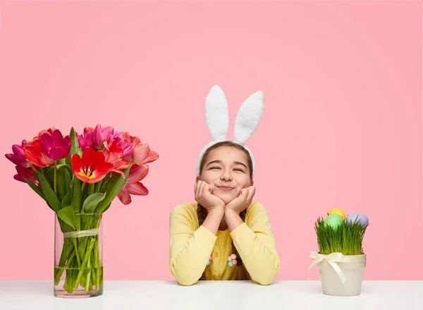 Adorable chica con tulipanes en la mesa para Pascua — Foto de Stock