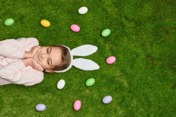 Gadis mimpi berbaring di halaman dengan telur Paskah — Stok Foto