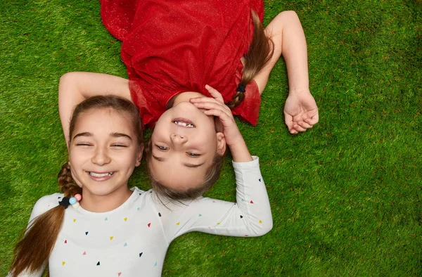 Adorables chicas acostadas sobre hierba verde — Foto de Stock