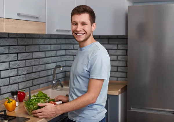 Красивий чоловік робить салат на кухні — стокове фото