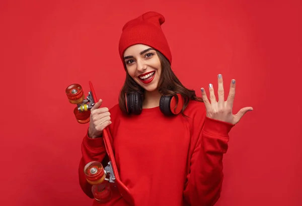 Elegante ragazza in abiti rossi in posa con longboard — Foto Stock